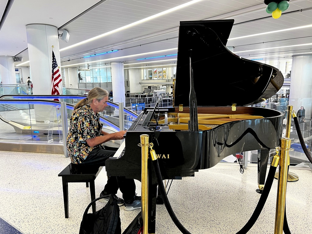 Matthew Cook playing piano while traveling